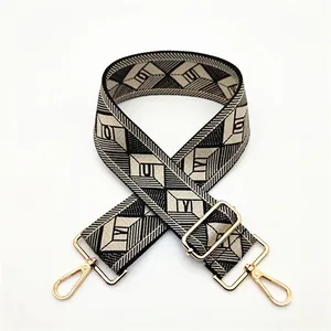 Detail of geometric jacquard shoulder strap with gold metal buckles and lobster clasps