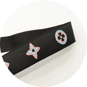 Detailed close-up of embroidered floral patterns on black adjustable bag strap