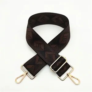 Close-up of adjustable geometric jacquard bag strap with gold metal lobster clasps