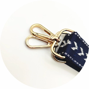 Detail of adjustable navy shoulder strap with white embroidery and gold swivel hooks