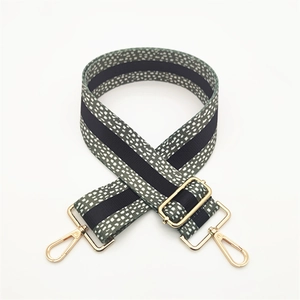 Adjustable dark green polka dot fabric shoulder strap with gold metal lobster clasps