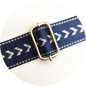 Detail of navy blue chevron strap with adjustable gold metal buckle for bags