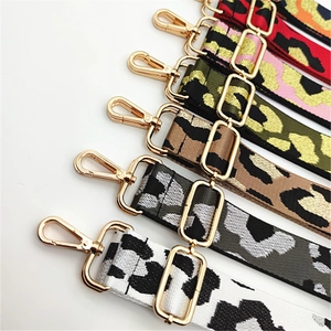 Detail of leopard print bag straps with gold metal hooks in multiple fashion colors