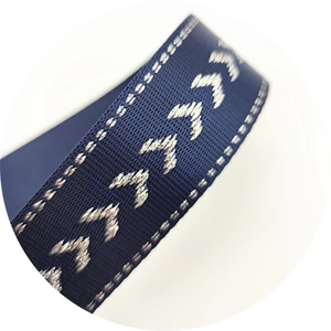 Macro detail of navy blue woven strap with silver metallic V-shaped pattern embroidery