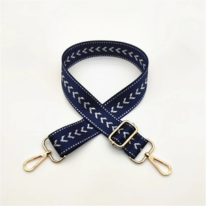 Adjustable dark blue bag strap with white V-shaped chevron pattern and gold metal hooks