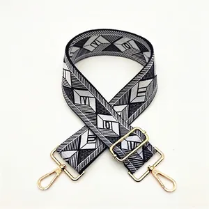 Close-up of geometric pattern weave strap with polished gold-tone metal buckles