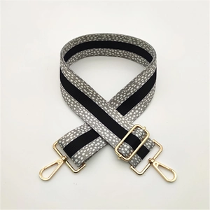 Close-up of adjustable woven shoulder strap with gray dots and gold metal swivel hooks