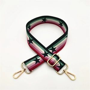 Detail of adjustable woven handbag strap with colorful stripes and black star patterns