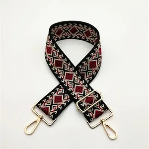 Detail of retro geometric diamond jacquard weave bag strap with gold metal hardware