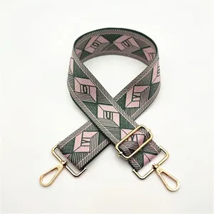 Close-up of pink and green diamond pattern fabric bag strap with gold swivel hooks
