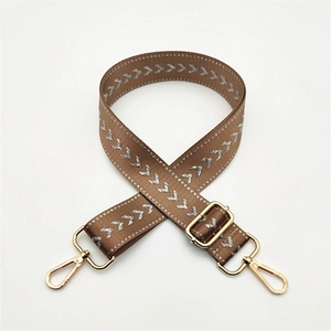 Adjustable brown nylon shoulder strap with silver V-pattern and gold metal hooks