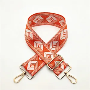 Close-up of adjustable wide bag strap with orange and white geometric diamond pattern