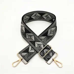 Detail of adjustable geometric diamond pattern bag strap with gold metal lobster clasps