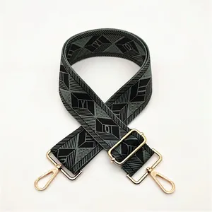 Detail of adjustable wide shoulder strap with green diamond pattern and gold hardware