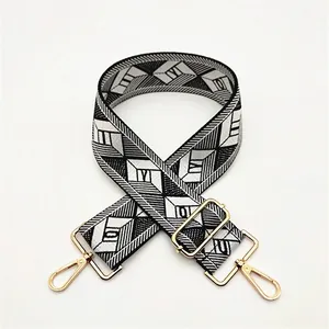 Detail of adjustable geometric diamond pattern shoulder strap with gold lobster clasps