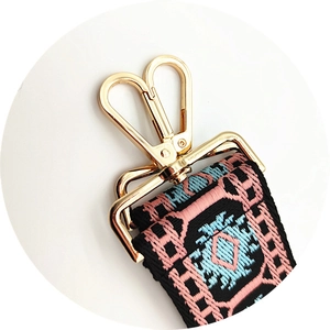 Detail of golden metal lobster clasp and thick jacquard bohemian style woven strap