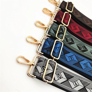 Detail of adjustable wide woven shoulder straps with geometric patterns and gold metal hooks