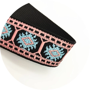 Close-up of ethnic geometric pattern woven strap with pink and blue diamond texture