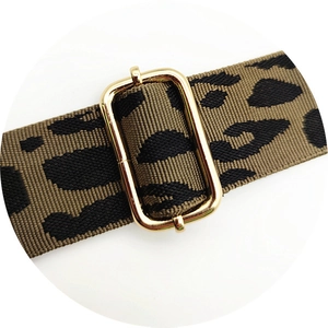 Macro shot of gold metal buckle on thick leopard print replacement shoulder strap