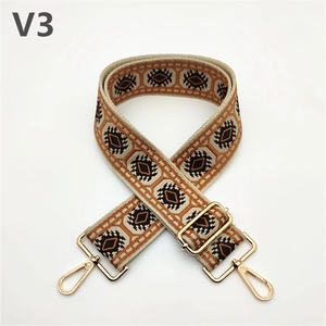 Detail of adjustable geometric ethnic strap with golden metal swivel hooks and buckle