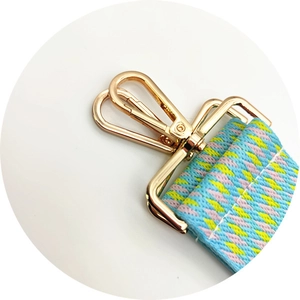 Macro shot of durable golden lobster clasp and colorful woven geometric bag strap