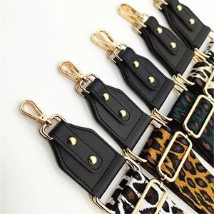 Detail of five leopard print bag straps with gold lobster clasps and black leather accents