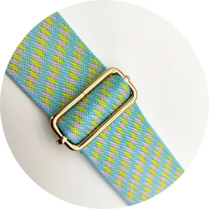 Close-up of geometric woven shoulder strap with gold metal buckle and colorful pattern