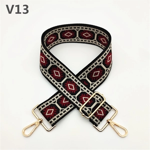 Detailed view of adjustable ethnic geometric pattern handbag strap with golden metal clasps