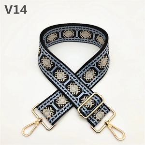 Close-up of ethnic geometric woven bag strap with golden lobster clasps and metal buckle