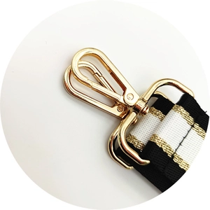 Close-up of golden lobster clasp with black and white striped webbing strap