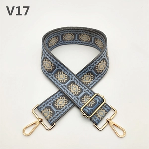 Detail of adjustable gray-blue ethnic style shoulder strap with gold metal hooks and buckle