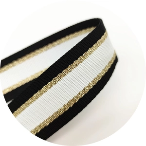 Thick adjustable crossbody bag strap in black and white webbing with gold metallic details