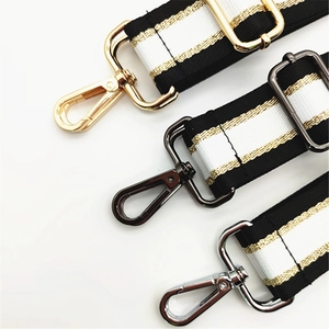 Detail of adjustable bag strap with black white stripes and gold thread weaving