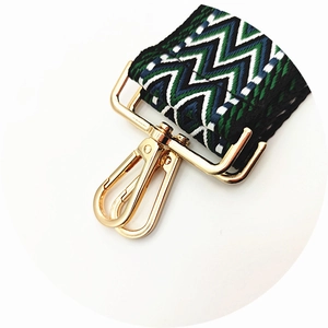 Detail of bohemian woven bag strap with ethnic patterns and gold metal lobster clasps