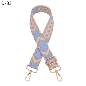 Close-up of diamond pattern woven strap with gold metal lobster clasps and buckles