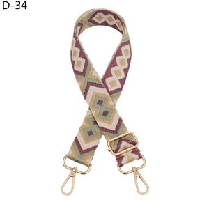 Detail of adjustable geometric diamond pattern bag strap with gold lobster clasps