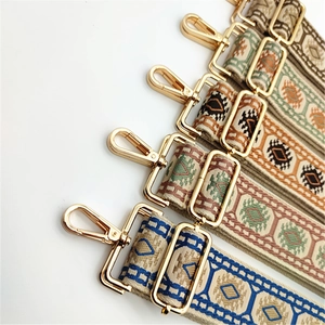 Detail of colorful jacquard guitar style bag straps with golden lobster clasps