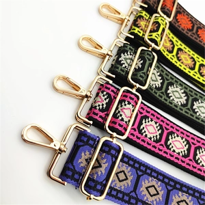 Close-up of colorful ethnic woven bag straps with gold metal hooks and geometric patterns
