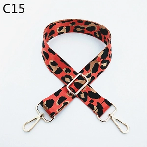 Macro shot of adjustable leopard print bag strap with golden metal hardware and buckle