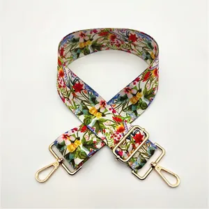 Close-up of a floral canvas bag strap with golden metal lobster clasps and adjustment buckle