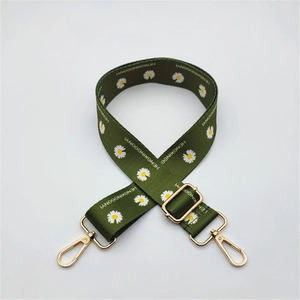 Detail of adjustable army green strap with white daisy pattern and gold metal hooks