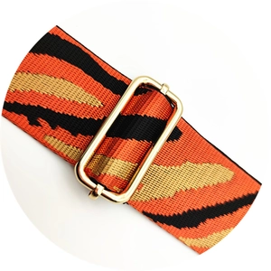 Gros plan de la bandoulière en nylon à motif tigre et boucle en métal doré poli