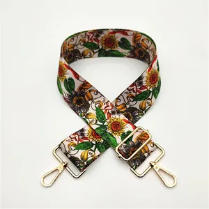 Detail of adjustable canvas bag strap with sunflower pattern and gold metal hardware