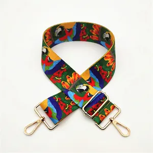 Detail of adjustable colorful tropical parrot and floral print canvas bag strap with gold hooks