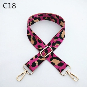Close-up of pink leopard print webbing strap with polished gold-tone metal buckles
