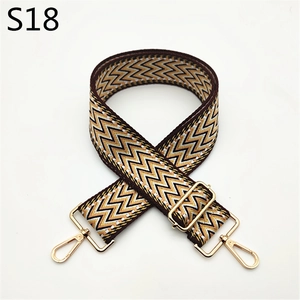 Macro shot of yellow and brown zigzag woven strap with shiny gold metal lobster clasps