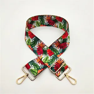 Detail of adjustable floral canvas strap with golden metal lobster clasps and buckles