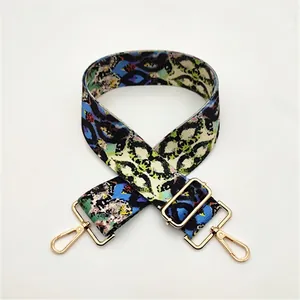 Detailed view of No. 5 snake pattern canvas strap with gold lobster clasps and metal buckle