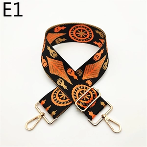 Close-up of bohemian woven shoulder strap with orange geometric patterns and gold clips