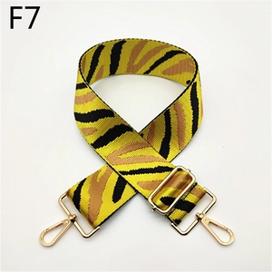 Détail de la bandoulière en nylon à motif zèbre jaune avec mousquetons dorés en métal